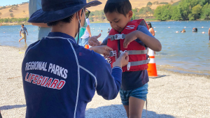 Lifeguard-helping-child-with-lifejacket