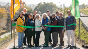 Attendees and Stakeholders cut ribbon at event celebrating Lafayette-Moraga Regional Trail Reopening after closure due to landslide in 2016