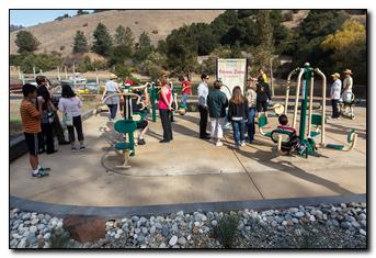 People checking out the new park fitness equipment