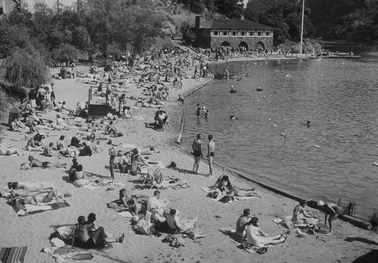 crowded beach, building in the background b&w
