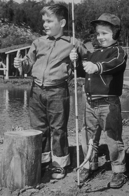 two children, one holding a fishing pole the other holding a fish b&w